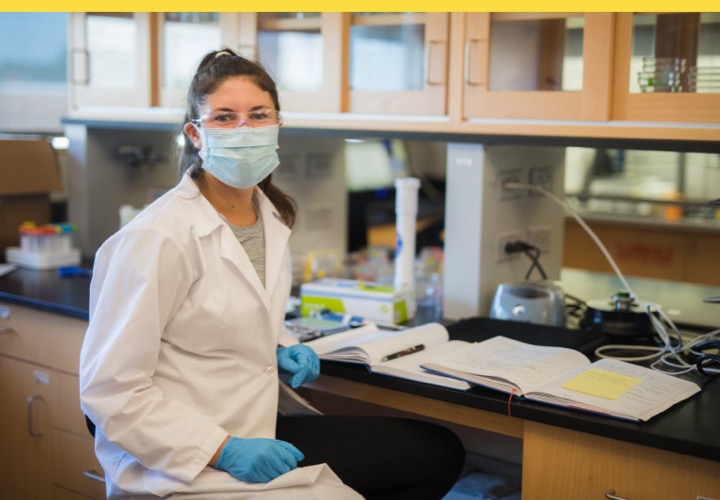 Woman in lab smiling at camera