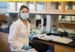 Woman in lab smiling at camera
